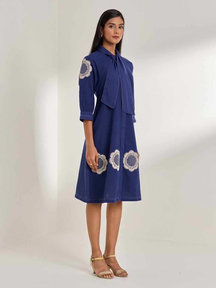 Blue cotton flax dress with embroidered motifs — structured and